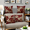 A set of red floral embroidered pillow covers featuring white and deep red flowers on a neutral sofa.