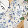 Blue and white porcelain floral linen table runner featuring detailed botanical patterns on a wooden surface.