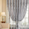 Gray vintage floral blackout curtain draped over a window with sheer lace overlay.