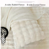 A close-up of a white rabbit fleece textile product showing its texture and softness.
