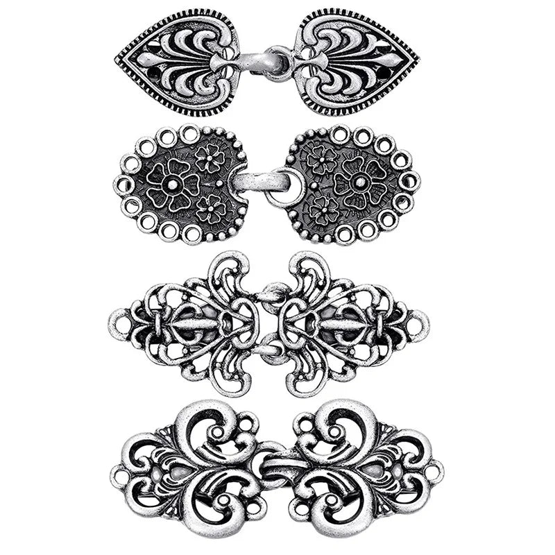 A set of vintage zinc alloy sweater clips featuring intricate floral and paisley designs.