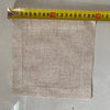 A square piece of natural linen fabric with stitched edges is shown next to a ruler.