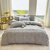 A gray marble print duvet cover set with pillows displayed on a bed near a bright window.