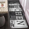 A long, rectangular floor mat with the text 'KITCHEN' vertically displayed in a rustic font on a dark background.