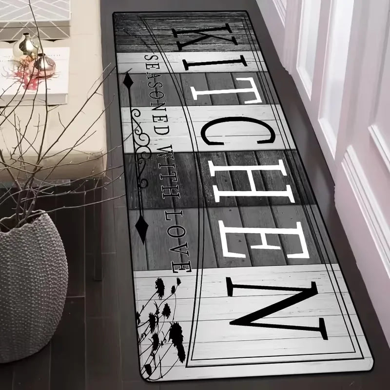 A long, rectangular floor mat with the text 'KITCHEN' vertically displayed in a rustic font on a dark background.