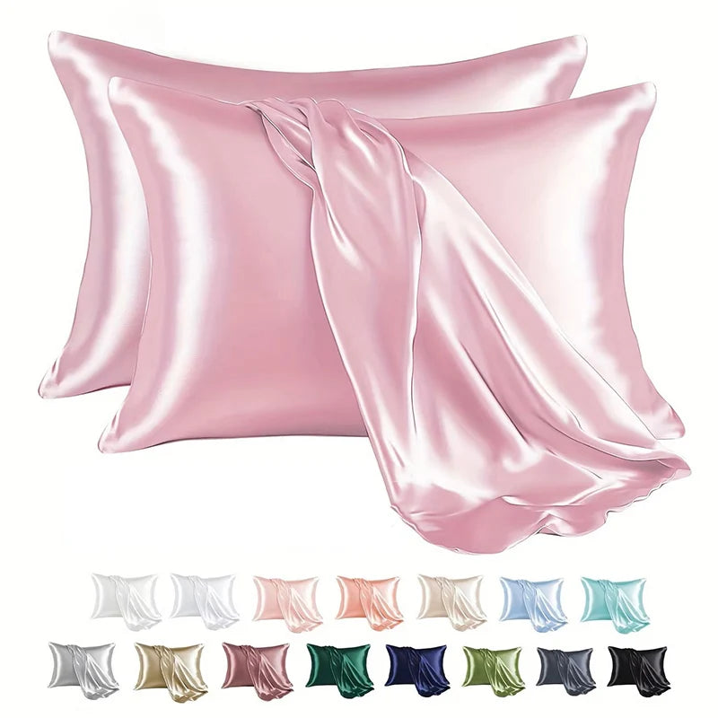 A set of pink satin pillowcases folded and displayed, with various shades including white, blush, and green.