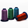 Three spools of high tenacity polyester embroidery thread in purple, green, and teal colors.