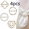 A set of four elegant gold-toned metal clips and a white silk scarf displayed against a light background.