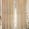 Cream sheer double layer blackout curtains with floral lace detailing hanging in a doorway