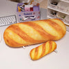 A loaf of bread shaped like a baguette is displayed next to a small purple storage box and some plush items.