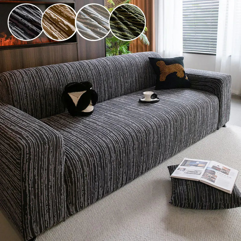 A dark gray Jacquard plush elastic sofa cover with a textured fabric and decorative throw pillows on a light rug.