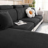 A dark gray thick jacquard sofa seat cushion cover with a white decorative pillow and a cup on the fabric.
