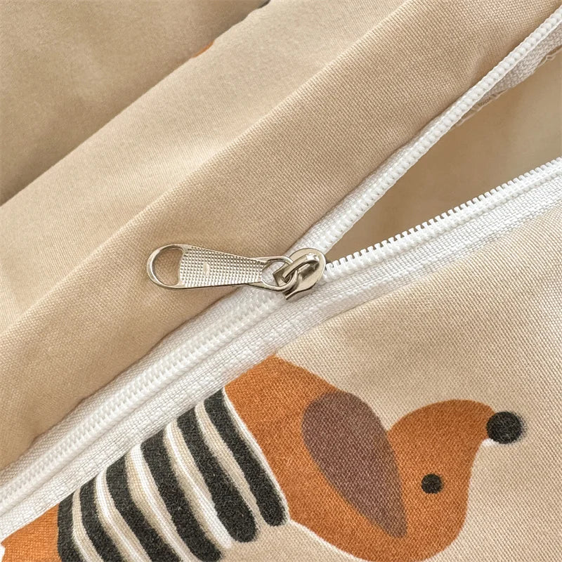 Close-up of a beige duvet cover with a brown and black striped dog print and a silver zipper.