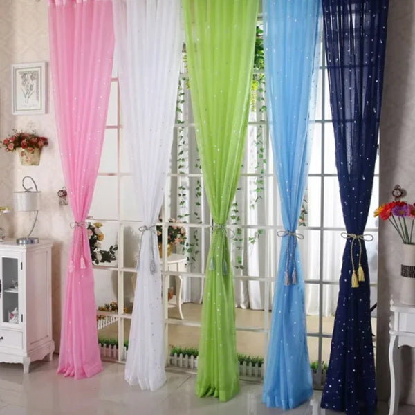A collection of elegant silver star tulle curtains in pink, white, lime green, blue, and navy hanging in a window.