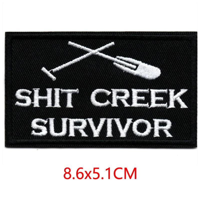 Black embroidered patch featuring a crossed fork and knife design above the text SHIT CREEK SURVIVOR