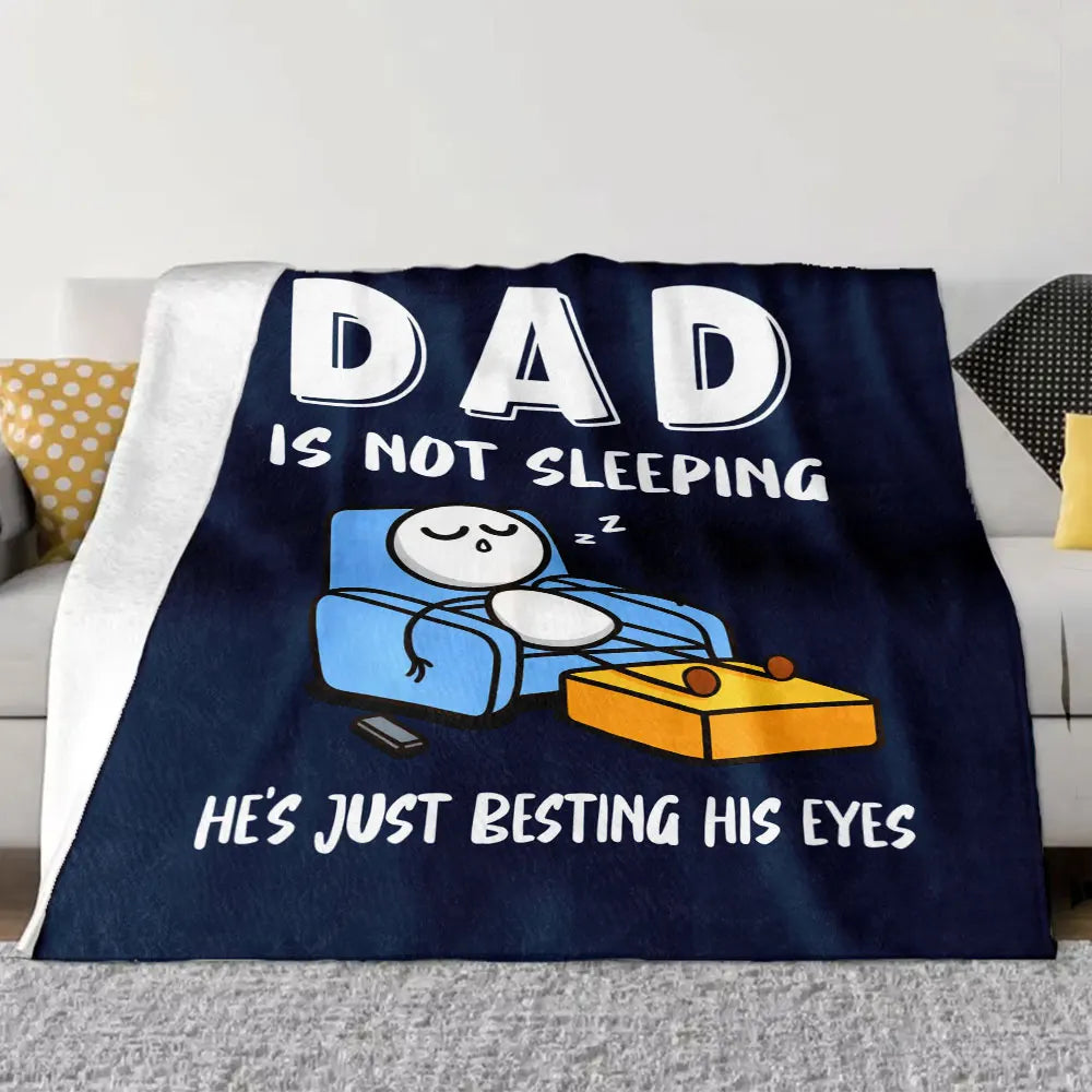 A dark blue blanket with white text humorously stating Dad is not sleeping and is besting his eyes.