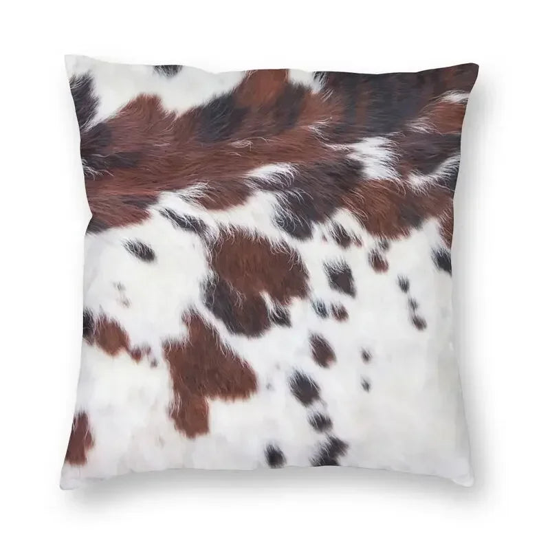 A square cushion cover featuring a brown and white cowhide print faux fur design.