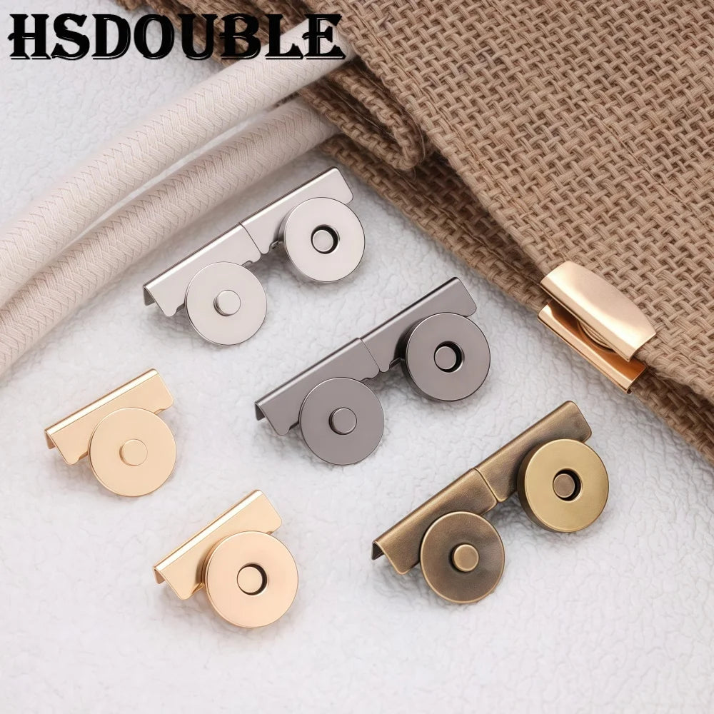 A collection of seamless magnetic button clasps in gold and silver tones displayed on a beige fabric background.