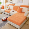 An orange leaf jacquard stretch sofa cover with anti-slip backing displayed on a white sofa.