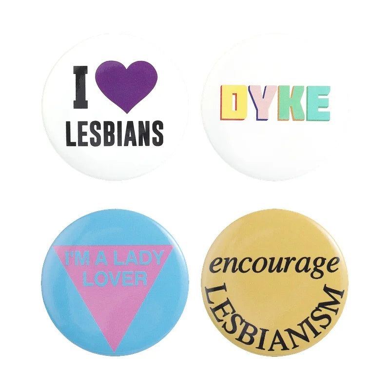 A set of four tinplate pins featuring designs like I love lesbians, Dyke, I'm a lady lover, and encourage lesbianism.