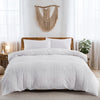 White tufted microfiber duvet cover set displayed on a bed with natural fiber macrame wall decor.