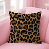 A square decorative pillow cover with a brown and black leopard print fabric resting on a pink sofa.