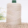 A spool of beige 3mm ice rope crochet yarn with a green cap resting on a woven mat.