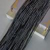 Black decorative door string curtains with gold accents displayed on a light surface.
