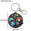 A black enamel pin keychain featuring a colorful color wheel design.