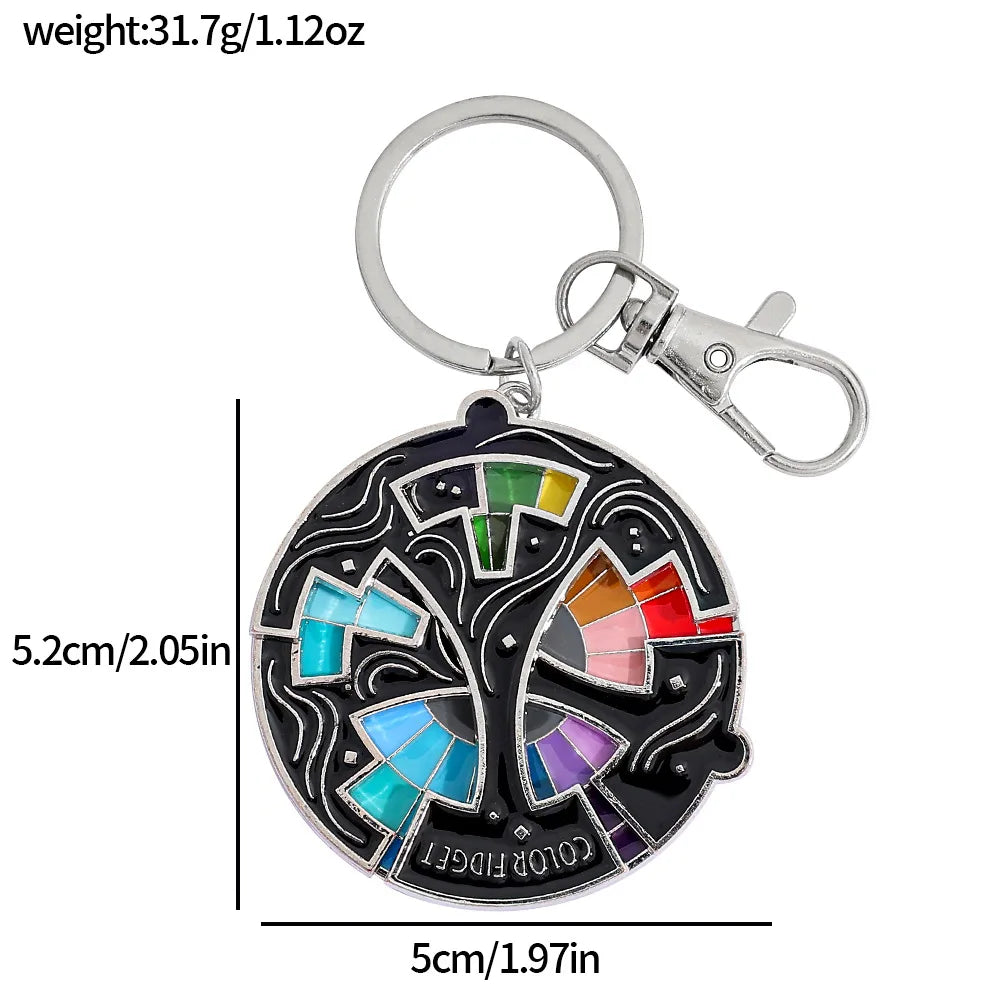 A black enamel pin keychain featuring a colorful color wheel design.