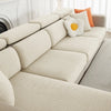 A beige jacquard elastic sofa cushion slipcover with decorative round pillows on a light-colored sofa.