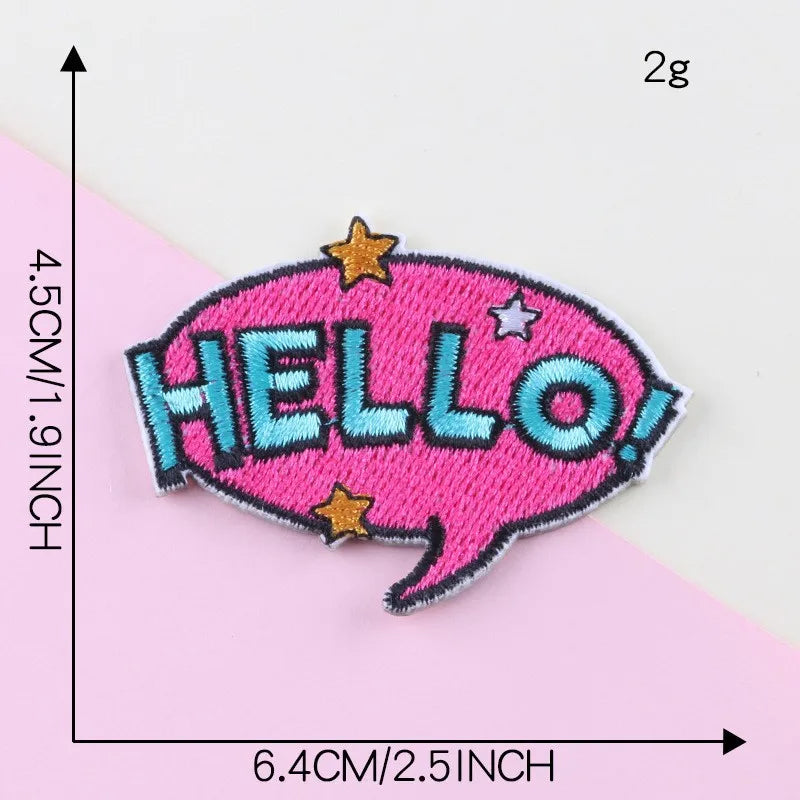 Pink embroidery patch with the word HELLO in blue stitching and gold stars on a pink background