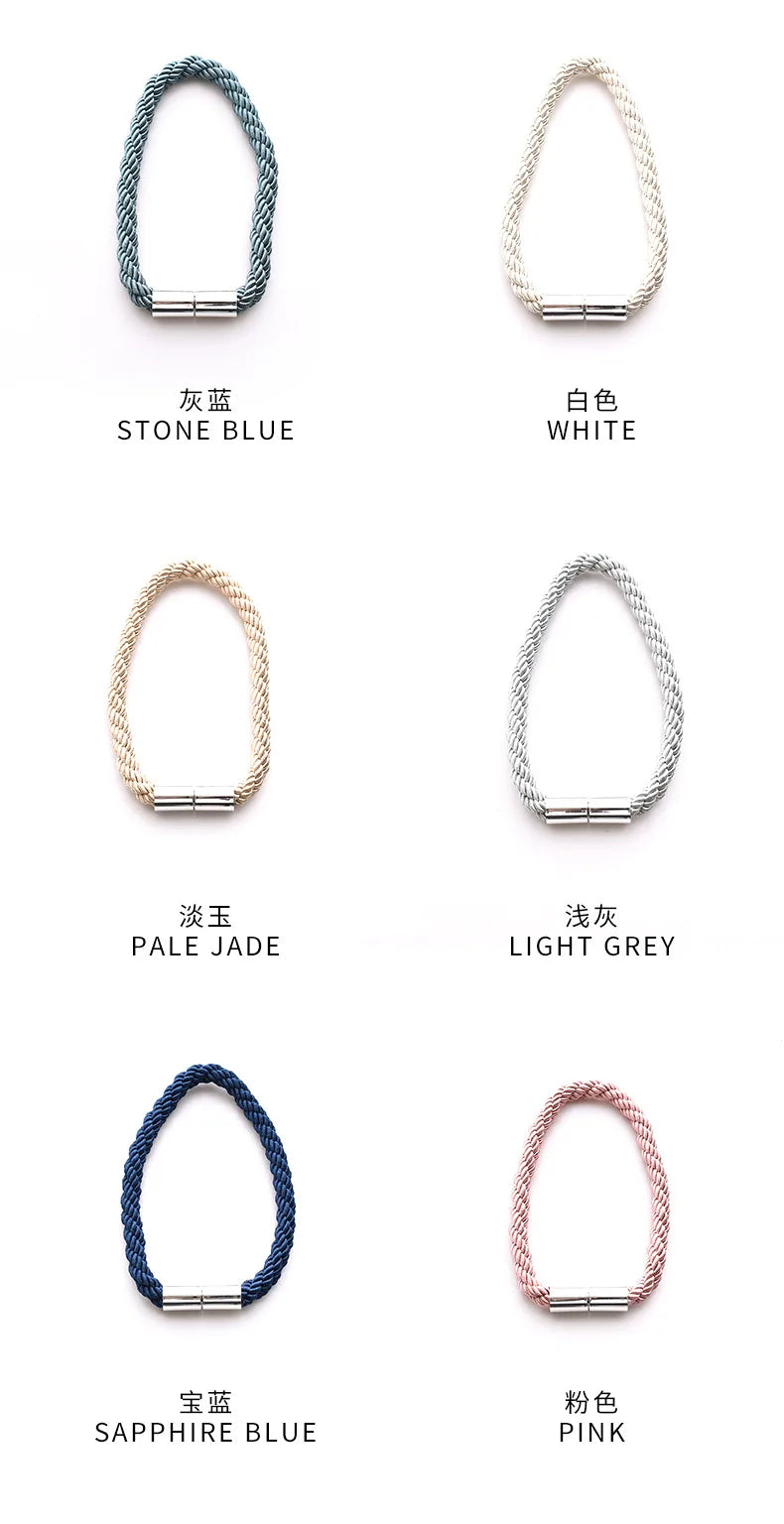 A collection of magnetic curtain tieback clips in various colors including stone blue, white, pale jade, light grey, sapphire