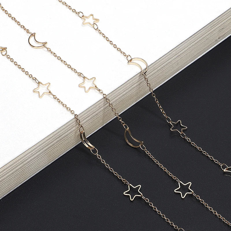 Gold-toned star and crescent moon necklace displayed on a dark background.