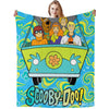 A colorful flannel throw blanket featuring a Scooby-Doo themed design with cartoon characters and a vehicle.