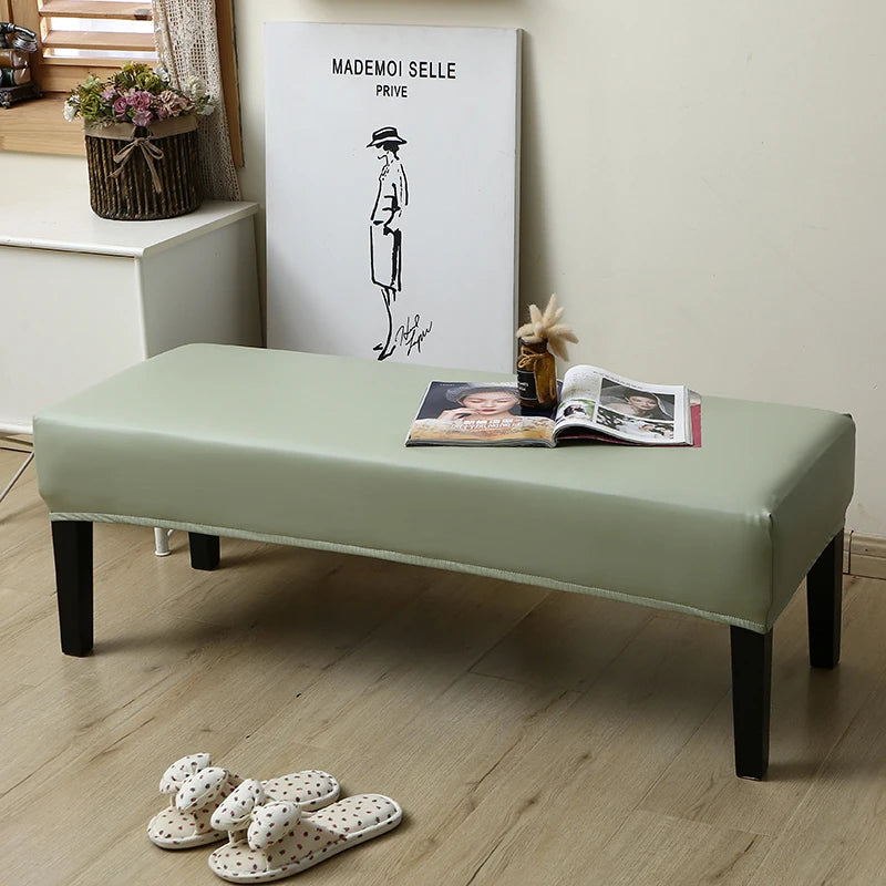 A light green dining bench cover is displayed on a wooden bench, with a framed sign in the background.
