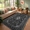A black and white cowhide print area rug placed in a bright living room with a light sofa and potted plants.