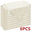 A stack of six beige textured cloth napkins with fringed edges.