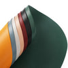A stack of colorful reusable vinyl placemats in various shades of green, brown, orange, and beige.