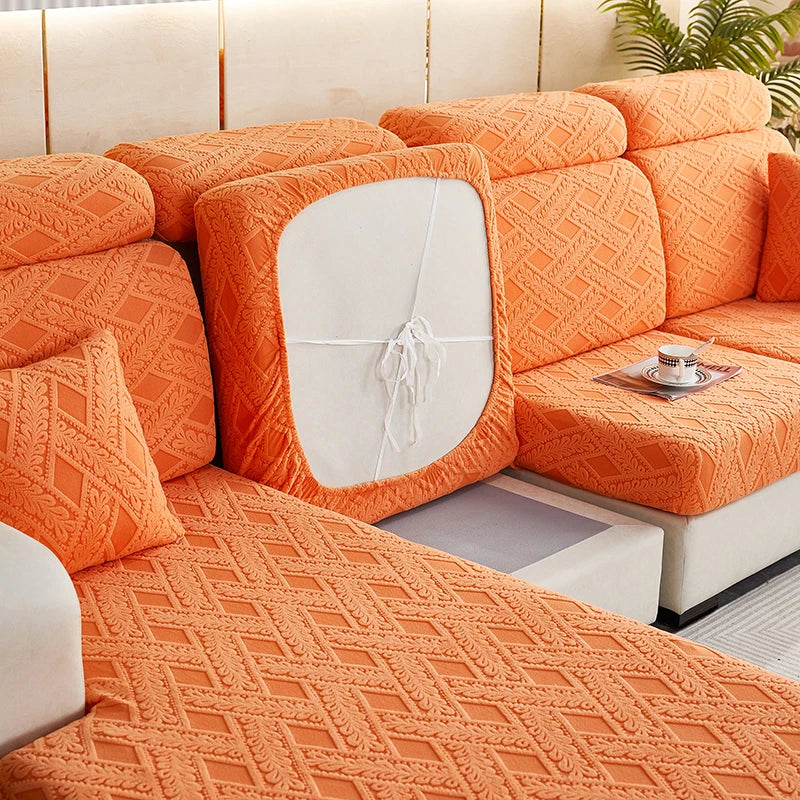 An orange jacquard plush sofa cushion cover featuring a geometric pattern on a modern sectional sofa.