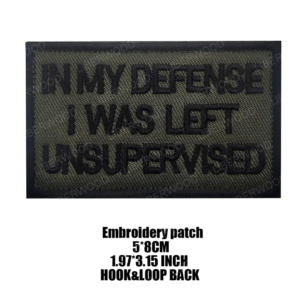 Black embroidered patch with text IN MY DEFENSE I WAS LEFT UNSUPERVISED on a tan background