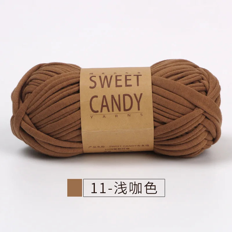 A ball of brown hand-dyed fabric strip yarn labeled Sweet Candy Yarns