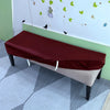 A maroon stretch pu leather waterproof bench slipcover placed on a light gray floor.