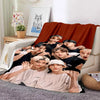 A group of male Kpop idols are printed on a large orange fleece throw blanket.