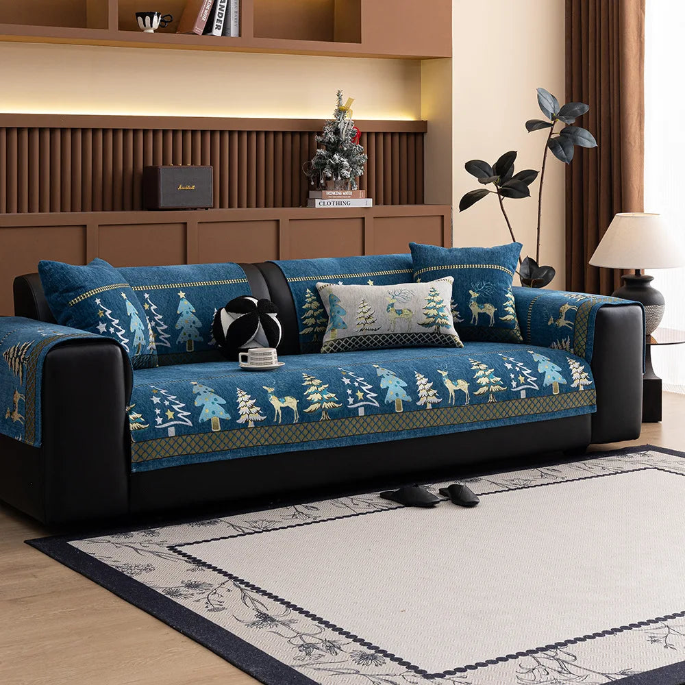 A dark blue sofa with a Christmas deer pattern mat cover sits in a modern living room.