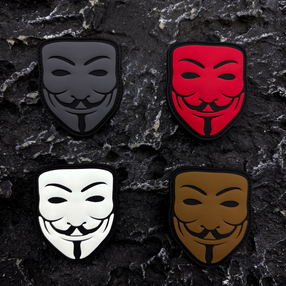 Three embroidered patches featuring different smiley face designs in black, red, and gold on a dark textured background.