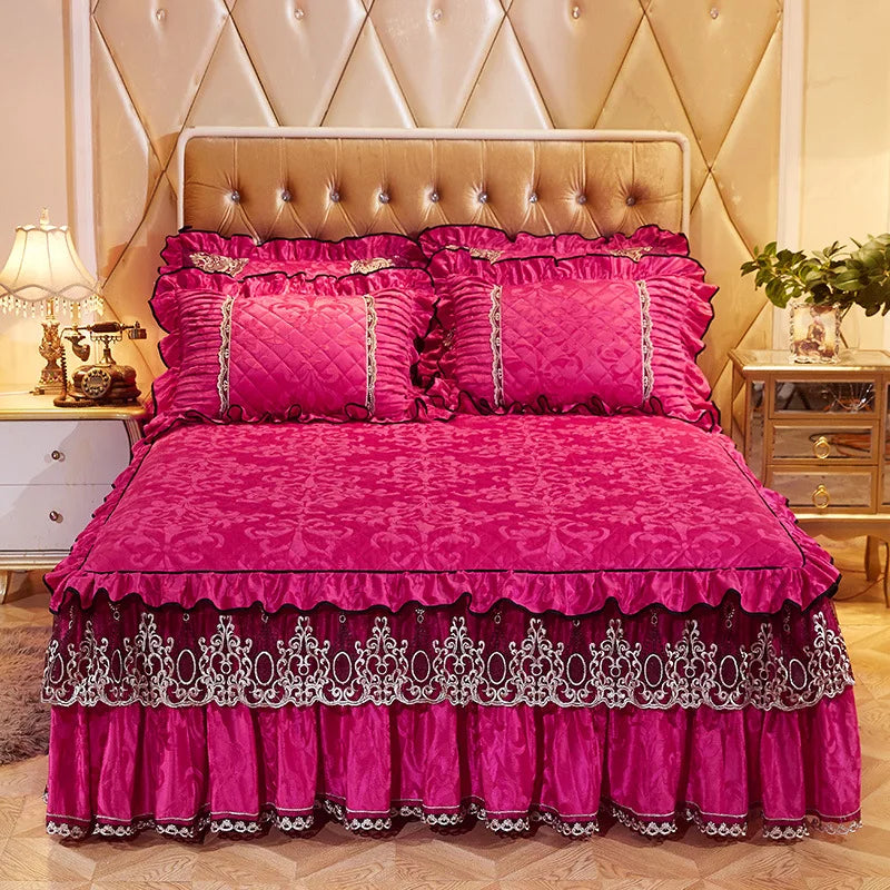 A vibrant pink quilted bed skirt set featuring a ruffled fabric and matching pillowcases on a bed.