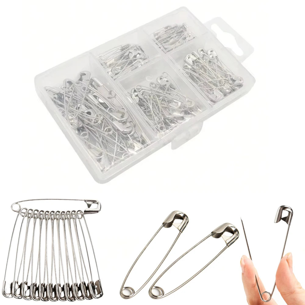 A clear plastic storage box filled with assorted stainless steel safety pins and various types of metal pins.