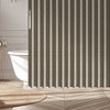 A vertical pleated curtain in beige and gray stripes hangs in a bathroom or closet setting.