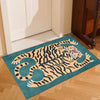 A teal rug featuring a stylized orange and black tiger with tropical palm leaf accents on a wooden floor.